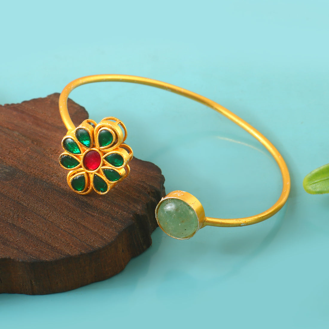 Gold Kundan Bangle Adorned with Green and Red Stones in Ornate Traditional Pattern