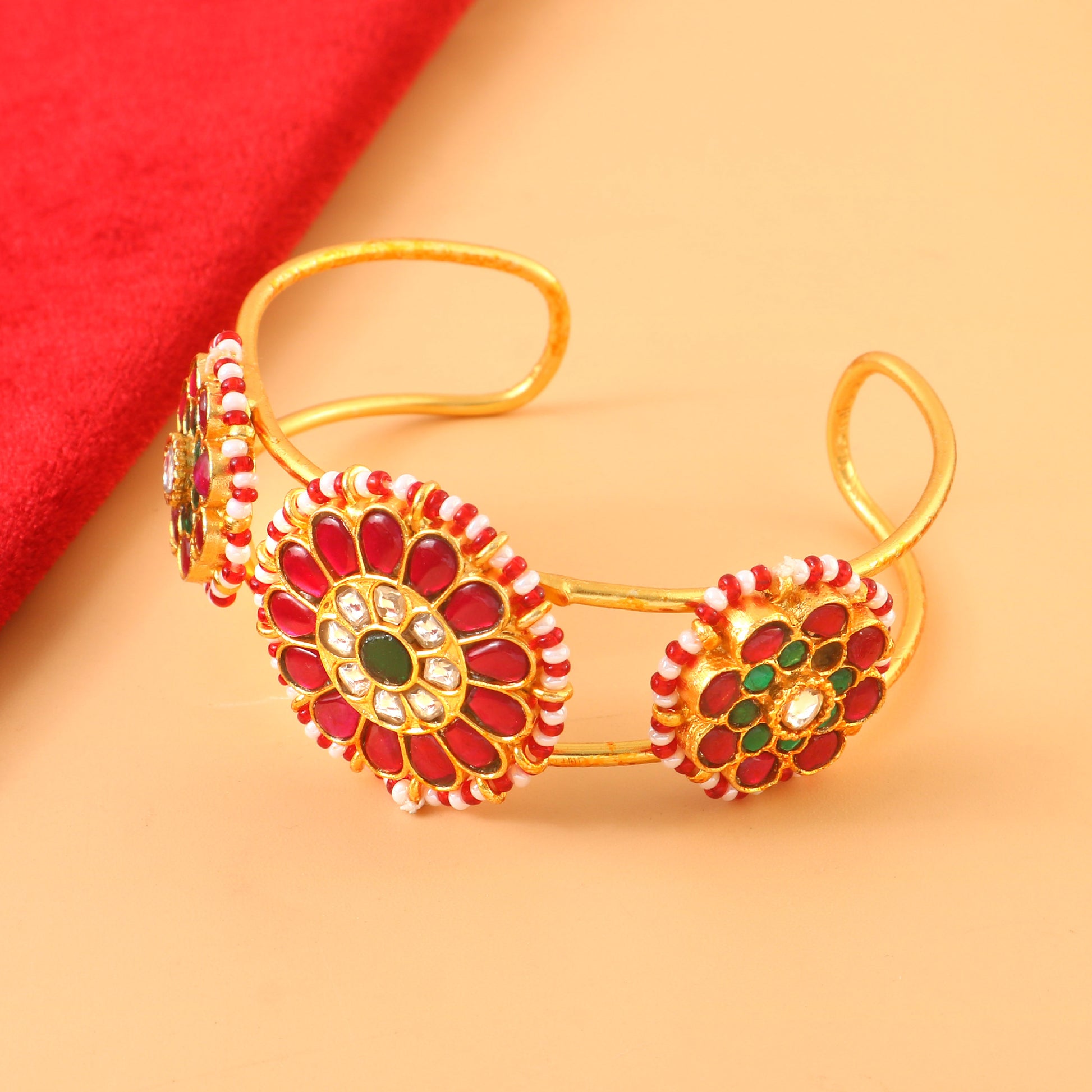 Elegant Gold Jadau Kundan Bangle with Red Floral Design and Green Center Stones.